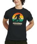 Man bär svart t-shirt med humoristiskt Bigfoot-motiv i vintagestil