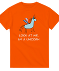 Glad tecknad enhörning med rosa detaljer och text på orange t-shirt.