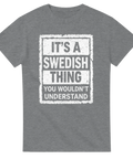 It's a Swedish Thing" texttryck i vitt med sliten effekt på grå t-shirt.