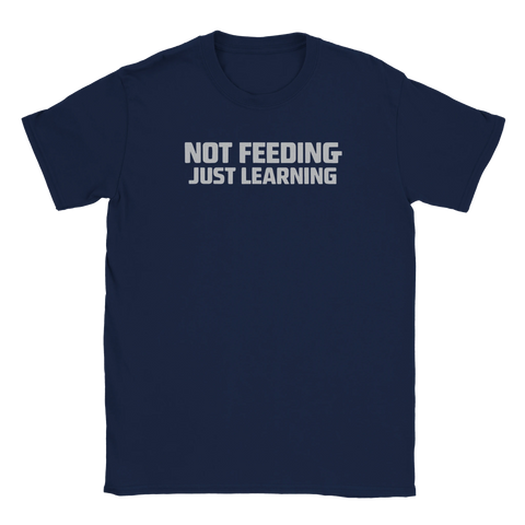 NOT FEEDING JUST LEARNING" texttryck i grått på en mörkblå t-shirt.