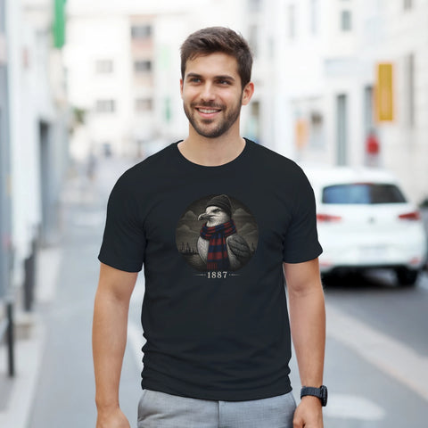 Leende man utomhus i en svart t-shirt med ett nostalgiskt måsmotiv i retrostil