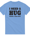 I NEED A HUG FROM A BAD BOY" text i sliten svart stil på ljusblå t-shirt.