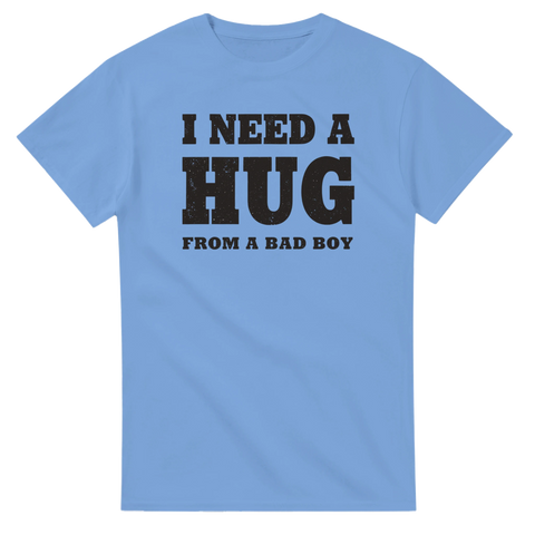 I NEED A HUG FROM A BAD BOY" text i sliten svart stil på ljusblå t-shirt.