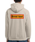 beige hoodie med ryggtryck och texten bred last