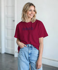 Kvinna i vinröd t-shirt med retroinspirerad grafisk textdesign