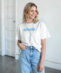 Leende kvinna i vit t-shirt med blått Höger-tryck