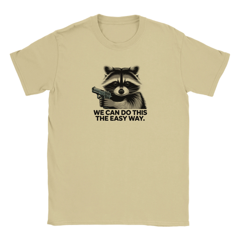Beigefärgad t-shirt med absurd illustration av en tvättbjörn som ger ett ultimatum