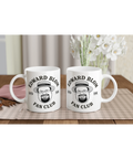 Två vita kaffemuggar med Edward Blom Fan Club motiv på ett dukat bord
