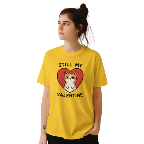Grinig katt i rött hjärta, text "STILL MY VALENTINE" på gul t-shirt.