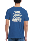 You are doing great" text i bubblig stil med blommor och smiley på blå t-shirt.