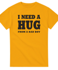 I need a hug from a bad boy" texttryck i sliten stil på gul t-shirt.