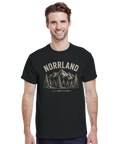 Leende man i t-shirt med grafiskt Norrland-tryck och skogsmotiv