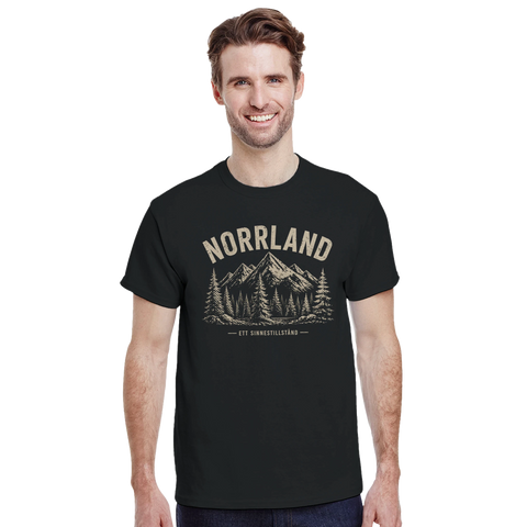 Leende man i t-shirt med grafiskt Norrland-tryck och skogsmotiv