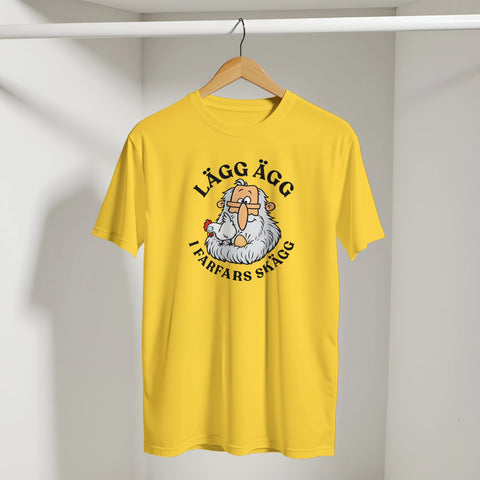 Gul t-shirt med farfar, en höna och texten ”Lägg ägg i farfars skägg”. På galge.