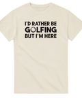 I'D RATHER BE GOLFING BUT I'M HERE" med golfboll på krämvit t-shirt.