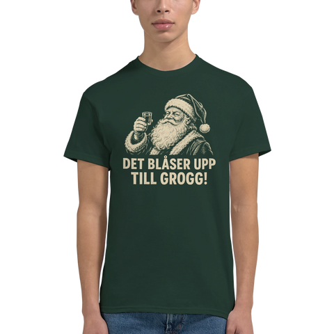Man bär mörkgrön t-shirt med roligt julmotiv av en skålande tomte
