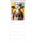 Väggkalender 2026 med popkonst-ko i kockmössa och förkläde på rosa/gul bakgrund.