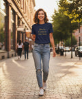 Kvinna i stadsmiljö bär marinblå t-shirt med positivt budskap