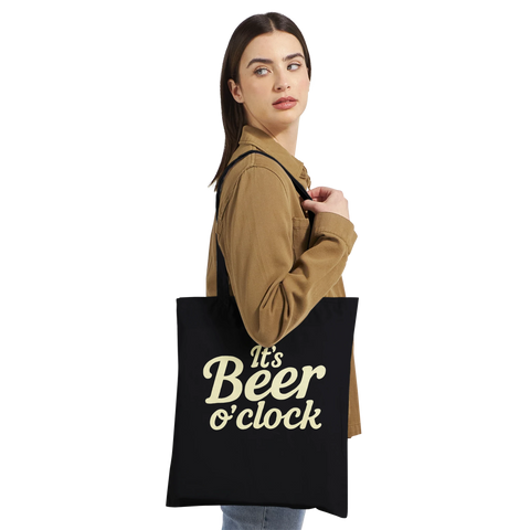 Kvinna som bär en tygkasse med ett skämtsamt budskap om öl