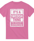 It's a Swedish Thing" text med distressed-effekt på rosa t-shirt.