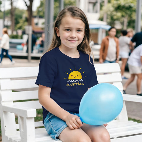 Tecknad glad sol med texten "Mammas Solstråle" på en marinblå barnt-shirt.