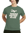 Flygplansmotiv med text "10000 METER CLUB" på grön t-shirt.