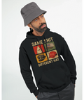 Satiriskt tryck "Same Shit Different Hat" med KKK-huva, sydstatsflagga, nazistmössa, MAGA-keps på svart hoodie.