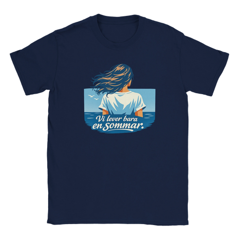 Kvinnas rygg, blått hår, text "Vi lever bara en sommar" över hav och himmel på marinblå t-shirt.