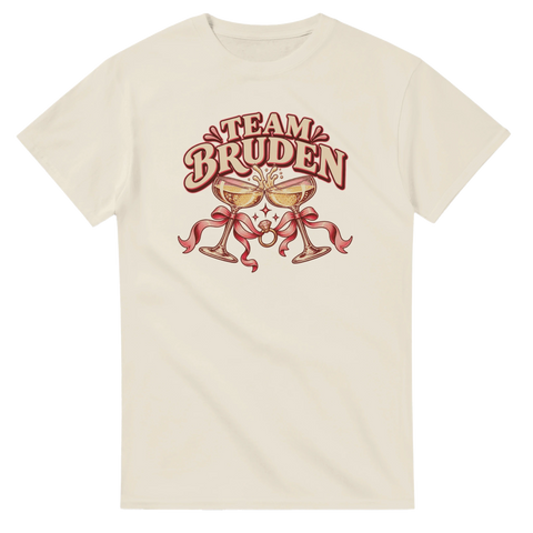 Beige t-shirt med champagneglas, rosett, ring och texten ”Team bruden”.