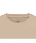 Svart minimalistisk "SHIRTY" logotyp på kragen av en beige premium herr-t-shirt i streetwear-stil.