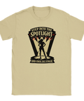 Scen med kvinna i spotlight, text "Step into the spotlight and own the stage" på beige t-shirt.