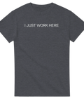 I JUST WORK HERE" texttryck i vitt, minimalistisk stil på mörkgrå t-shirt.