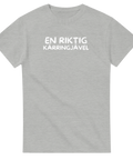 En riktig kärringjävel" text i vitt, bubbligt typsnitt på grå t-shirt.