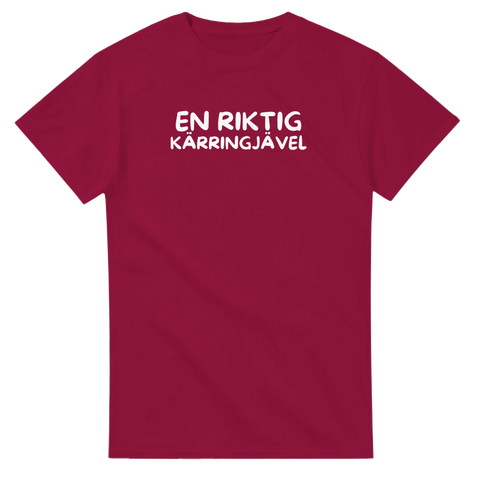 Satirisk text "EN RIKTIG KÄRRINGJÄVEL" i vitt på vinröd t-shirt.