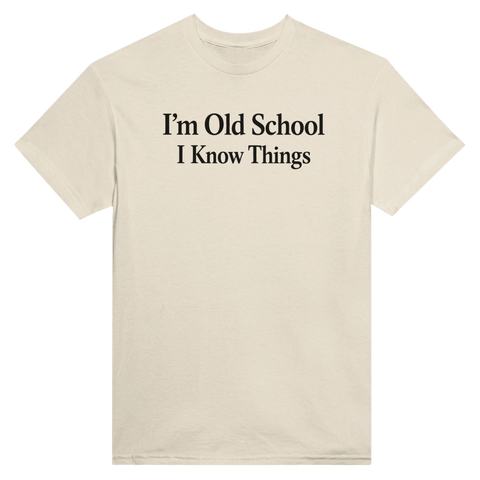 Svart text "I'm Old School I Know Things" på en beige t-shirt med rund hals.