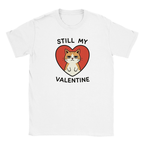 Grinig orangevit katt i rött hjärta med texten "Still My Valentine" på vit t-shirt.