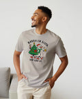 Modell i beige t-shirt med en julgran och snögubbe som skålar och texten ”Barra en sista, sen går vi”.