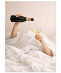 Närbild på bubblig champagne som hälls upp i ett glas i en ljus och lyxig sovrumsmiljö.