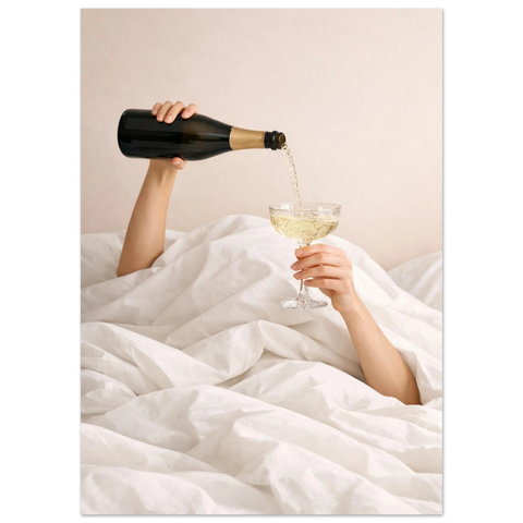Närbild på bubblig champagne som hälls upp i ett glas i en ljus och lyxig sovrumsmiljö.