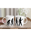 Vit kaffemugg med svart evolutionstryck som visar utvecklingen från apa till människa med kaffekopp
