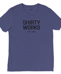 Shirty Works EST. 2025" svart text på mörkblå triblend t-shirt.