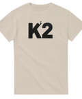 Äventyrligt K2-motiv med siluett av klättrare på sandfärgad t-shirt