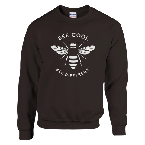 Vit stiliserad humla med text "BEE COOL BEE DIFFERENT" på mörkbrun sweatshirt.