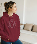 Vitt streckritat tentakelmonster med stora ögon på en vinröd hoodie.
