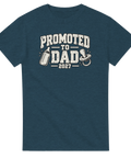 Blågrå t-shirt med texten Promoted to Dad 2027, nappflaska och napp.