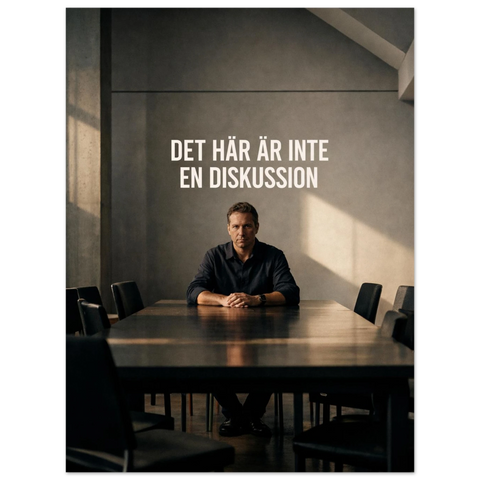 Poster med texten Det här är inte en diskussion ovanför en man vid ett långbord i ett avskalat betongrum.