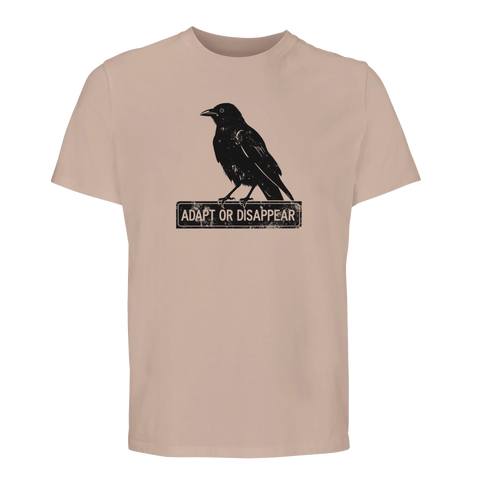 Svart kråka med texten "ADAPT OR DISAPPEAR" i sliten stil på en beige ekologisk T-shirt.