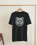 Svart t-shirt med björnmotiv och texten Papa Bear, hängande på galge