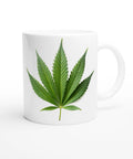 Vit mugg med tryck av ett grönt cannabisblad i minimalistisk design