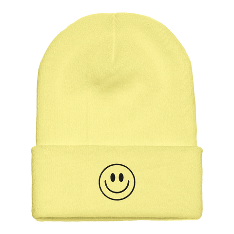 Gul mössa med mudd och broderad smiley på framsidan
